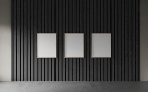 Black slatted acoustic wall panels with three minimalist picture frames, showcasing modern sound-dampening design for commercial or gallery interiors