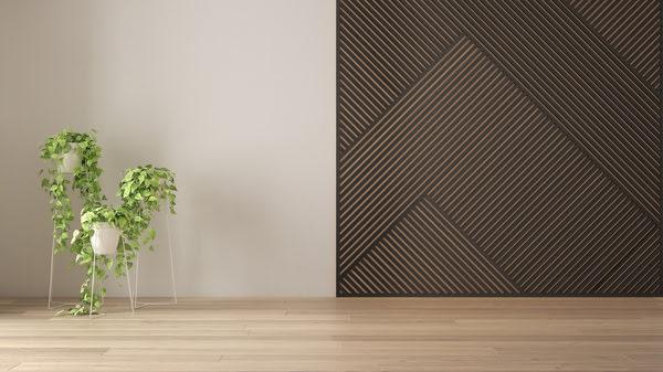 Modern interior with decorative diagonal black acoustic wall panels paired with natural wood flooring and indoor plants