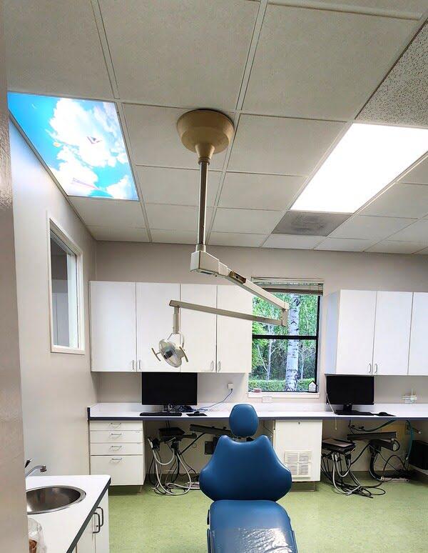 Ceiling tiles with lighting and sky panel in a dental clinic