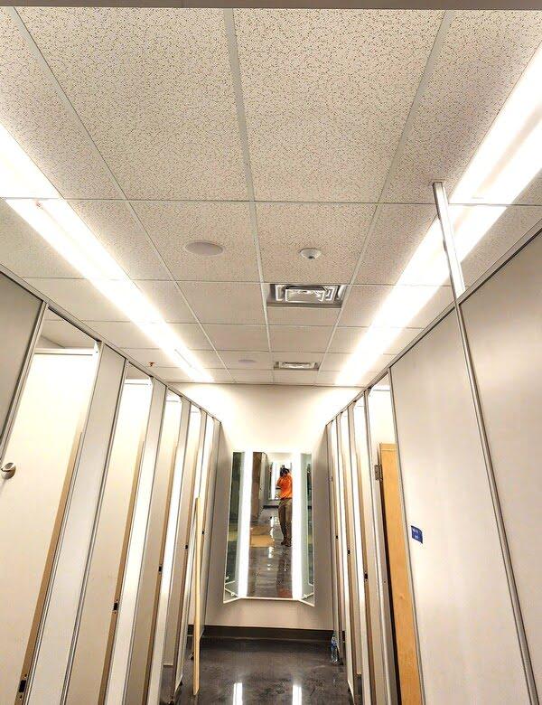 Acoustic ceiling tiles installed in a retail fitting room hallway